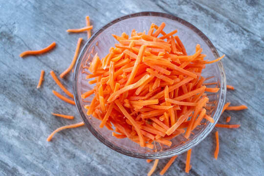 bowl full of orange julienne carrot sticks flat lay