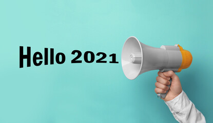 Hello 2021. Man holding megaphone on turquoise background, closeup