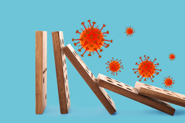 Concept of spreading coronavirus. Wooden domino tiles falling on blue background