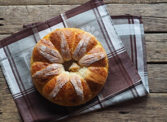 Homemade buns, on a kitchen napkin on a wooden background.Festive and casual, healthy and natural food.