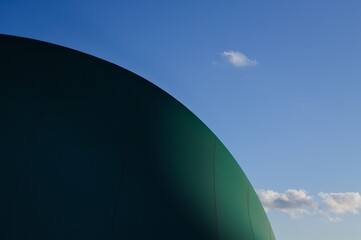 Clouds in the sky behind a pressure switch structure with a plastic cover of a sports building...