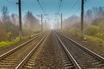 Fototapeta na wymiar Two straight parallel metal steel train rails with concrete sleepers