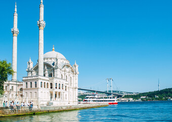 Fototapeta na wymiar The Ortakoy Mosque in the distance against the blue sky at Istanbul. It is located in the new part of the city in the Ortaköy area next to the Bosphorus Bridge.