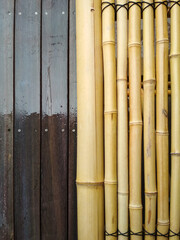 Wooden dark brown planks and bamboo stalks tied together. Abstract textured background.