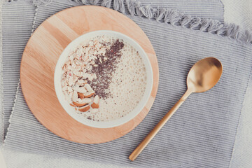 Healthy breakfast fruit smoothie bowl topped with almond, granola and chia seeds, snack banana and blueberry, flat lay