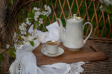 Coffee set on a white tablecloth, cherry blossom, chocolate, cocoa. Outdoor, picnic, brunch, spring mood. Soft focus