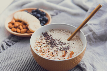 Healthy breakfast fruit smoothie bowl topped with almond, granola and chia seeds, snack banana and blueberry