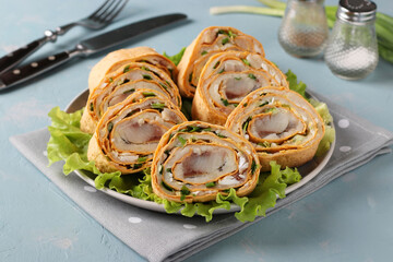 Lavash roll with herring, potatoes and onions on light blue background. Closeup