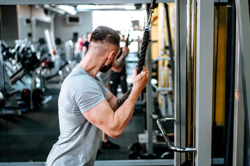 Fototapeta na wymiar Muscular man working out arms biceps at gym. Fitness life, healthy life concept