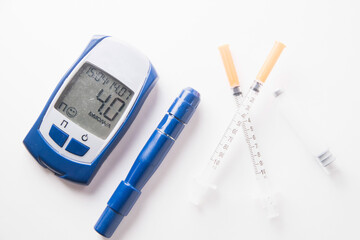 blood glucose meter and insulin syringes. diabetes mellitus.