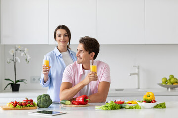 Happy young couple in love preparing healthy meal in kitchen.