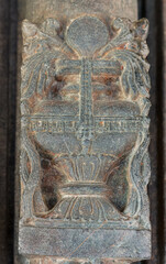 Lakkundi, Karnataka, India - November 6, 2013: Brahma Jinalaya temple. Closeup of gray stone vase figure sculpture on pilllar.