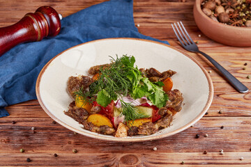 Fresh vegetable salad with giblets, wooden background