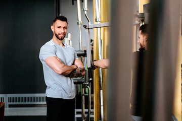 Fototapeta na wymiar Personal trainer wearing sportswear assisting man and leaerning bodybuilding