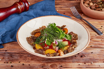 Fresh vegetable salad with giblets, wooden background
