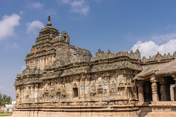 Fototapeta premium Lakkundi, Karnataka, India - November 6, 2013: Brahma Jinalaya temple. Closeup of sanctum with vimanam tower on top under blue cloudscape.
