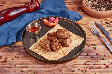 Grilled pork with vegetables, wooden background