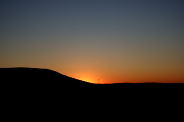 bonita puesta de sol con horizonte curvado y torres de electricidad en el fondo