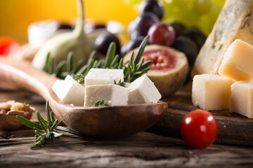 Set of different types of cheese on old wooden background, close up.