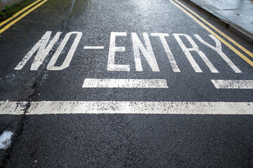 Fototapeta na wymiar No entry painted sign on a dark asphalt. Warning and traffic regulation concept