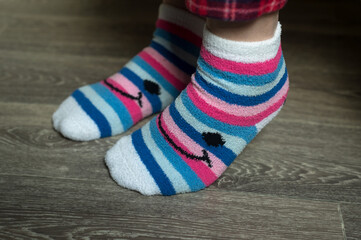 Obraz na płótnie Canvas Closeup of pink stripped socks on feet of woman at home