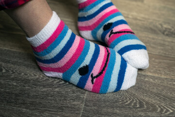 Fototapeta na wymiar Closeup of pink stripped socks on feet of woman at home