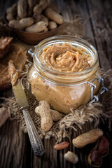 Fresh peanut butter on wooden ground, close-up