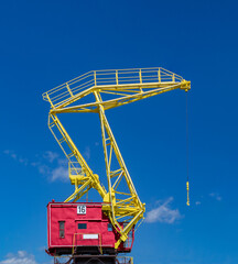 one colorful industrial crane on a blue sky background
