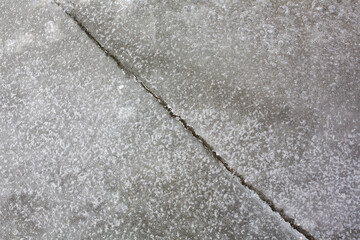 Big crack on an ice surface of the frozen water.