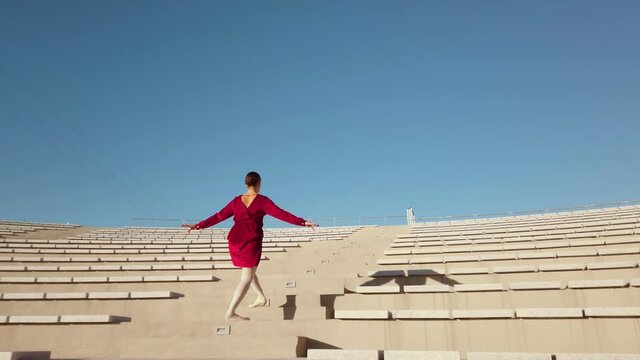 Ballerina con vestito rosso che balla al teatro aperto