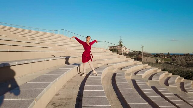 Ballerina con vestito rosso che balla al teatro aperto
