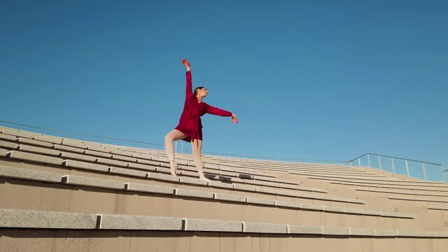 Ballerina con vestito rosso che balla al teatro aperto