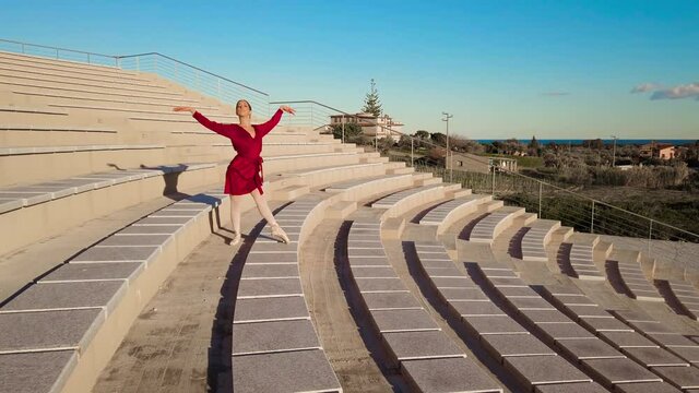 Ballerina con vestito rosso che balla al teatro aperto