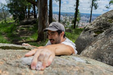 man climbing a boulder near the city