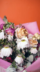 Close up of bouquet of wilted flowers. Variety of withered flowers in wrapping paper.