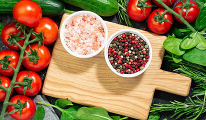 Wooden serving board with set of spices, herbs and vegetables for making juicy vegan salad top view. Tasty and healthy food concept.