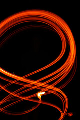 Abstract fiery pattern in the shape of the number 8. Drawing shapes with fire at night, infinity sign, bright colors on night background, fun with fire.