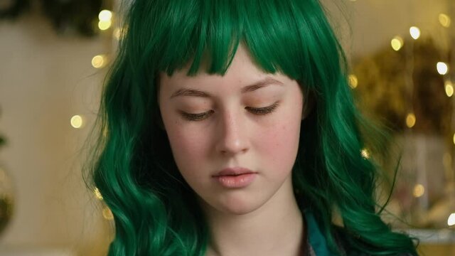 Video portrait of authentic beautiful teen caucasian girl with green coloured hair.