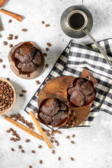 Cupcake. Chocolate muffins on a wooden serving board on a light gray kitchen table. Delicious sweet pastries. Coffee cupcakes on a light background	