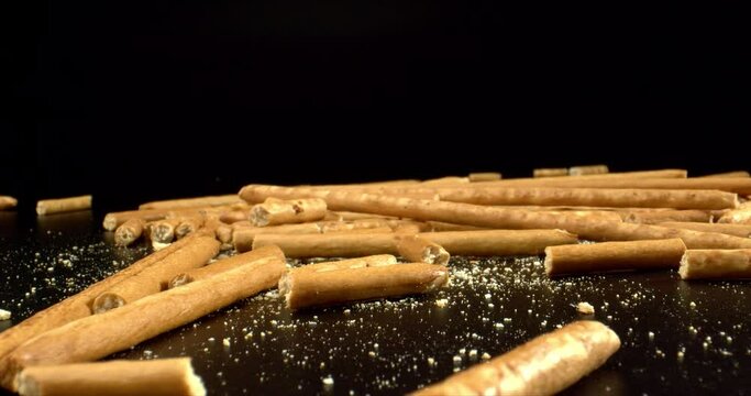 Salted Sticks Thrown Up. Bread sticks with salt lies on black surface. Delicious snack concept. High quality. 