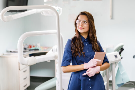 Young doctor in a dental clinic. Portrait of young female doctor dentist with digital tablet in dental office