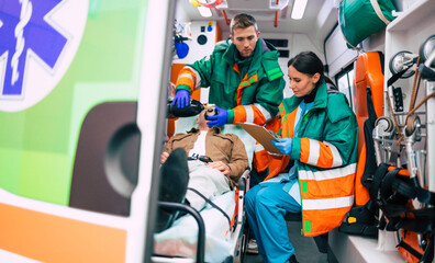 Emergency medical service team with senior patient in an ambulance