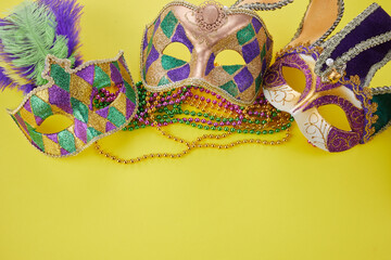 Mardi gras or carnival mask with beads on yellow background. Venetian mask.