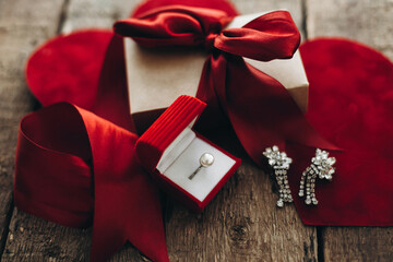 Happy Valentines day. Stylish gift box, luxury ring and earrings on rustic wood. Love and marriage