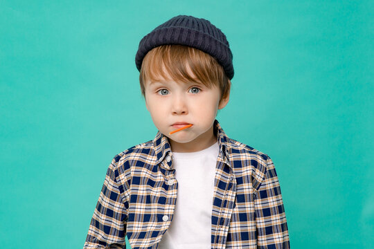 cute boy of five or six years old in a hat and a white T-shirt poses for the camera with a cute smile. Portrait
