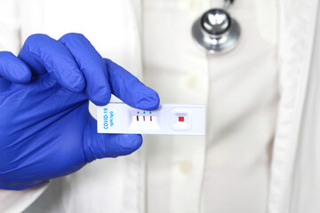 Medical worker holding positive Rapid Diagnostic Test cassette