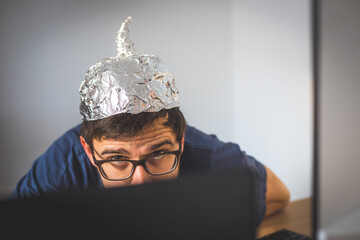 Conspiracy theory concept: young man is wearing aluminum head