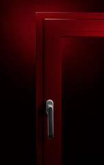 Detail of red aluminium window with handle on black background