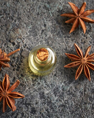 A bottle of essential oil with dried star anise