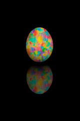 Easter egg painted with different colors, isolated on black bakcground.